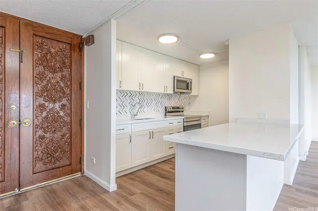 a kitchen with white cabinets and sink