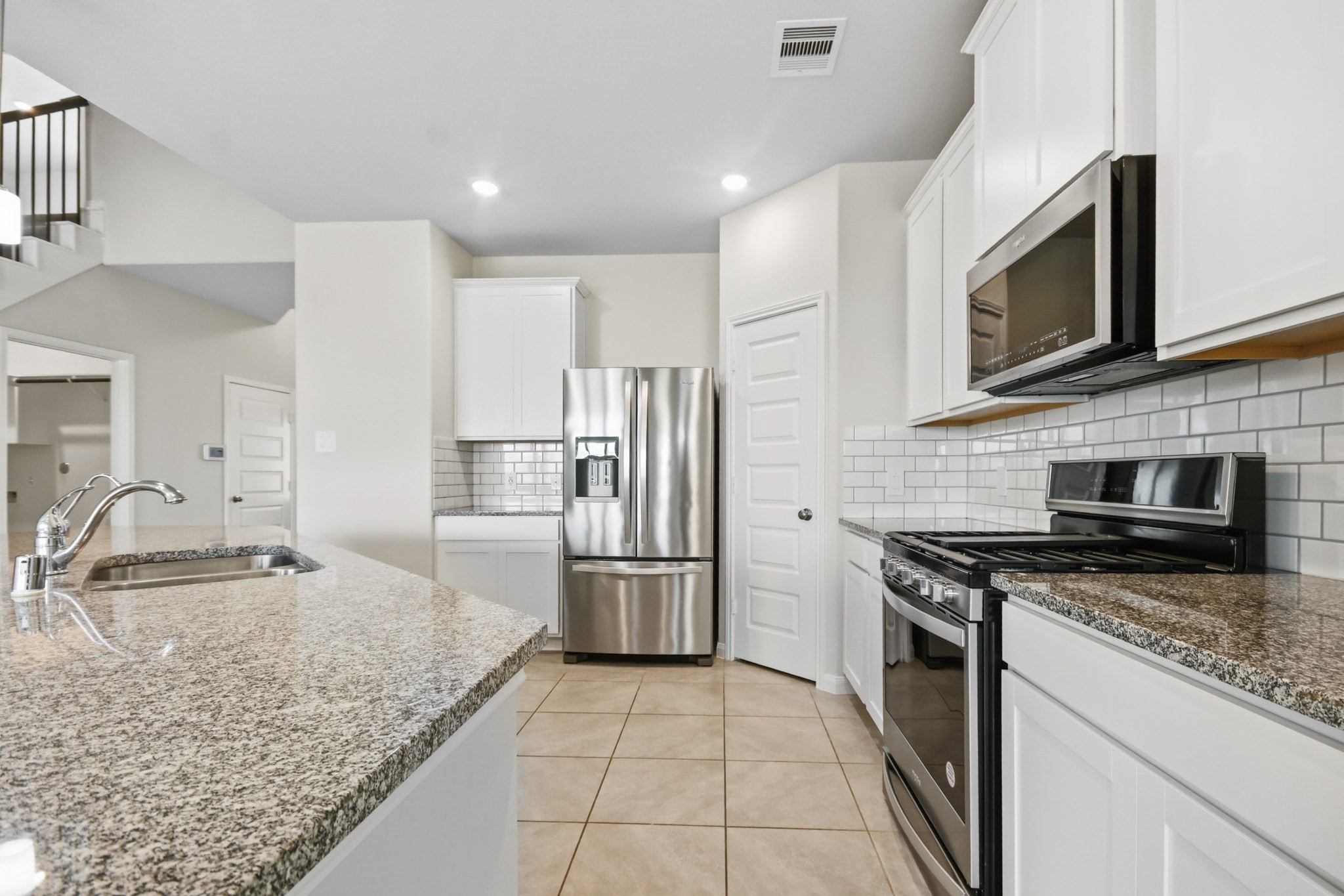 10723 Clfs Vw Drive Rosharon, TX 77583 - Photo 13 of 50 White cabinets, grey toned granite and white subway tiles complement the design of this kitchen!