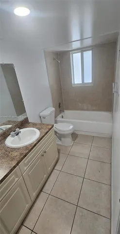 a bathroom with a granite countertop sink a toilet and a mirror