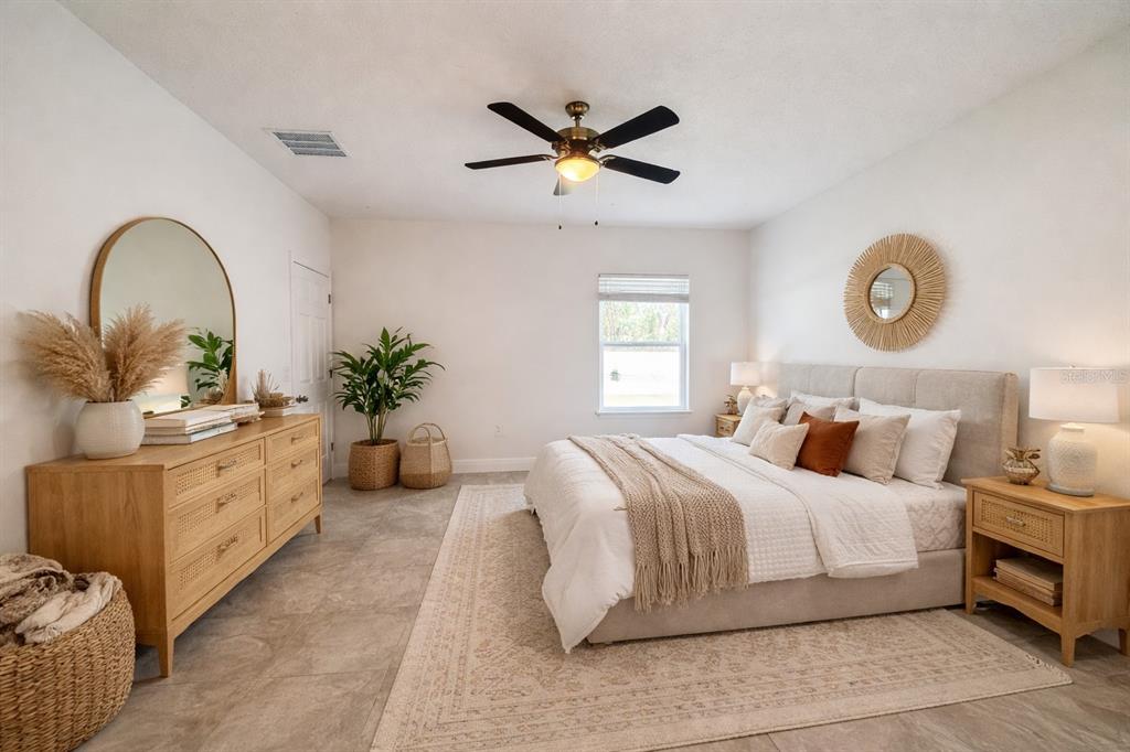 16054 Southwest 55th Avenue Road Ocala, FL 34473 - Photo 20 of 58 a bedroom with a large bed and a chandelier