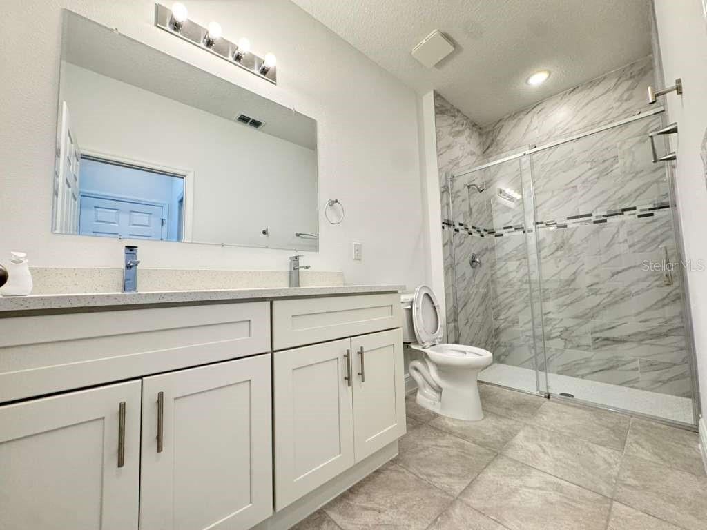 16054 Southwest 55th Avenue Road Ocala, FL 34473 - Photo 25 of 58 a bathroom with a double vanity sink toilet and shower
