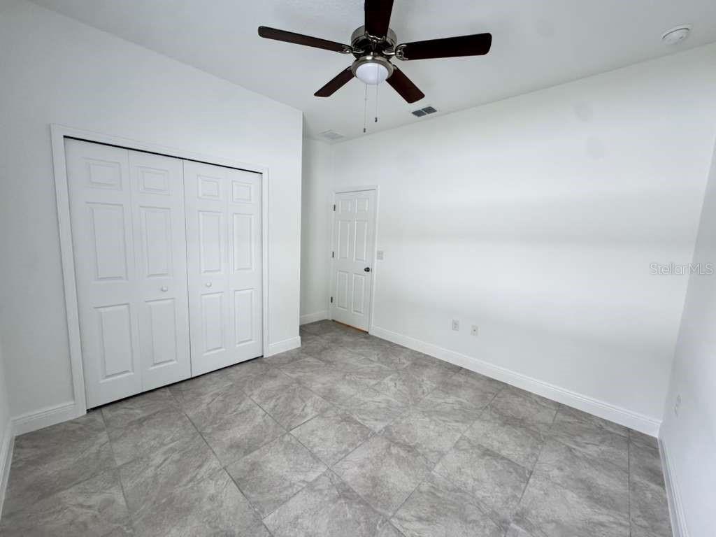 16054 Southwest 55th Avenue Road Ocala, FL 34473 - Photo 32 of 58 an empty room with a ceiling fan and a window