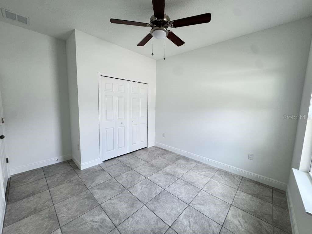 16054 Southwest 55th Avenue Road Ocala, FL 34473 - Photo 34 of 58 an empty room with a ceiling fan and carpet