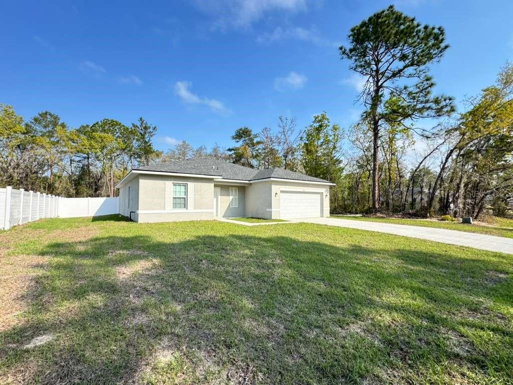 16054 Southwest 55th Avenue Road Ocala, FL 34473 - Photo 4 of 58 a front view of a house with a yard and trees
