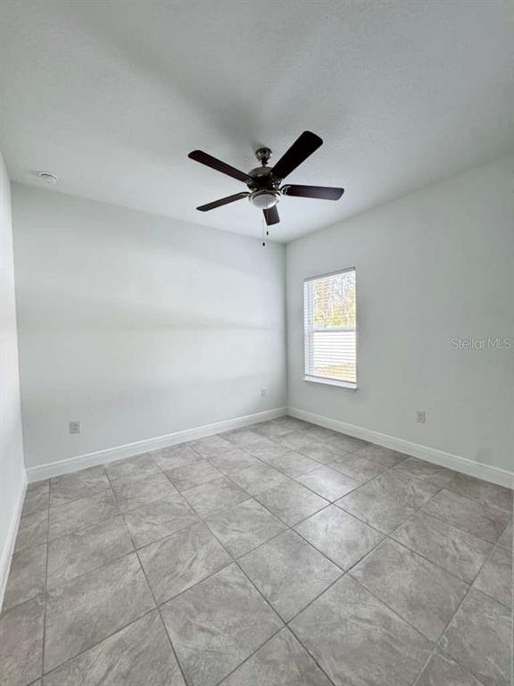 16054 Southwest 55th Avenue Road Ocala, FL 34473 - Photo 47 of 58 an empty room with windows and ceiling fan view