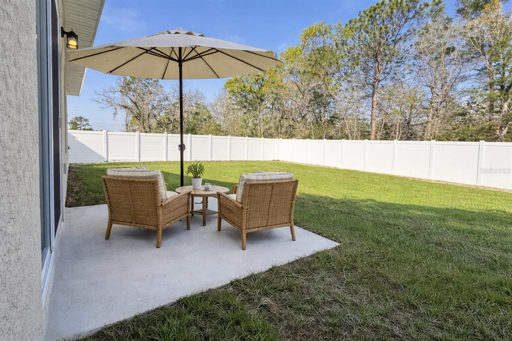 16054 Southwest 55th Avenue Road Ocala, FL 34473 - Photo 50 of 58 an outdoor sitting area with furniture and umbrella