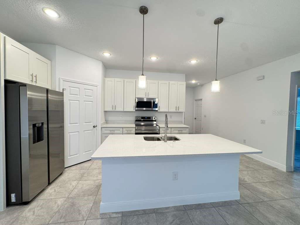 16054 Southwest 55th Avenue Road Ocala, FL 34473 - Photo 6 of 58 a large kitchen with refrigerator a oven and a sink