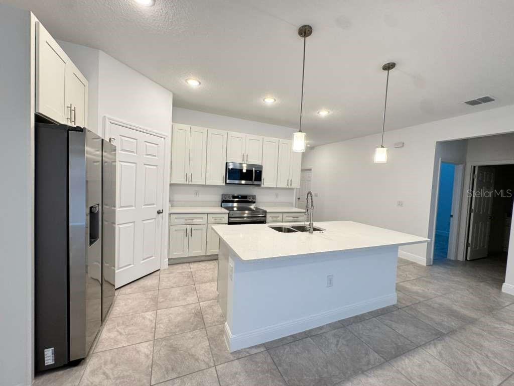 16054 Southwest 55th Avenue Road Ocala, FL 34473 - Photo 8 of 58 a large kitchen with stainless steel appliances kitchen island granite countertop a refrigerator a oven a sink and a granite counter tops