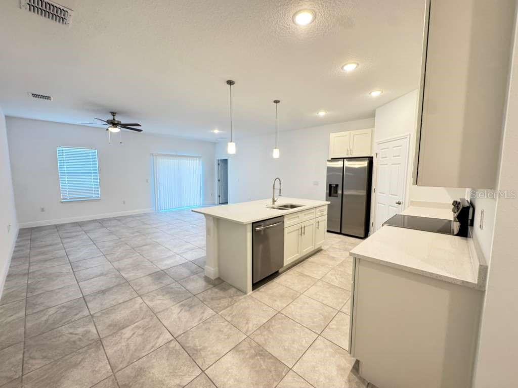 16054 Southwest 55th Avenue Road Ocala, FL 34473 - Photo 10 of 58 a kitchen with a sink a refrigerator and a stove top oven
