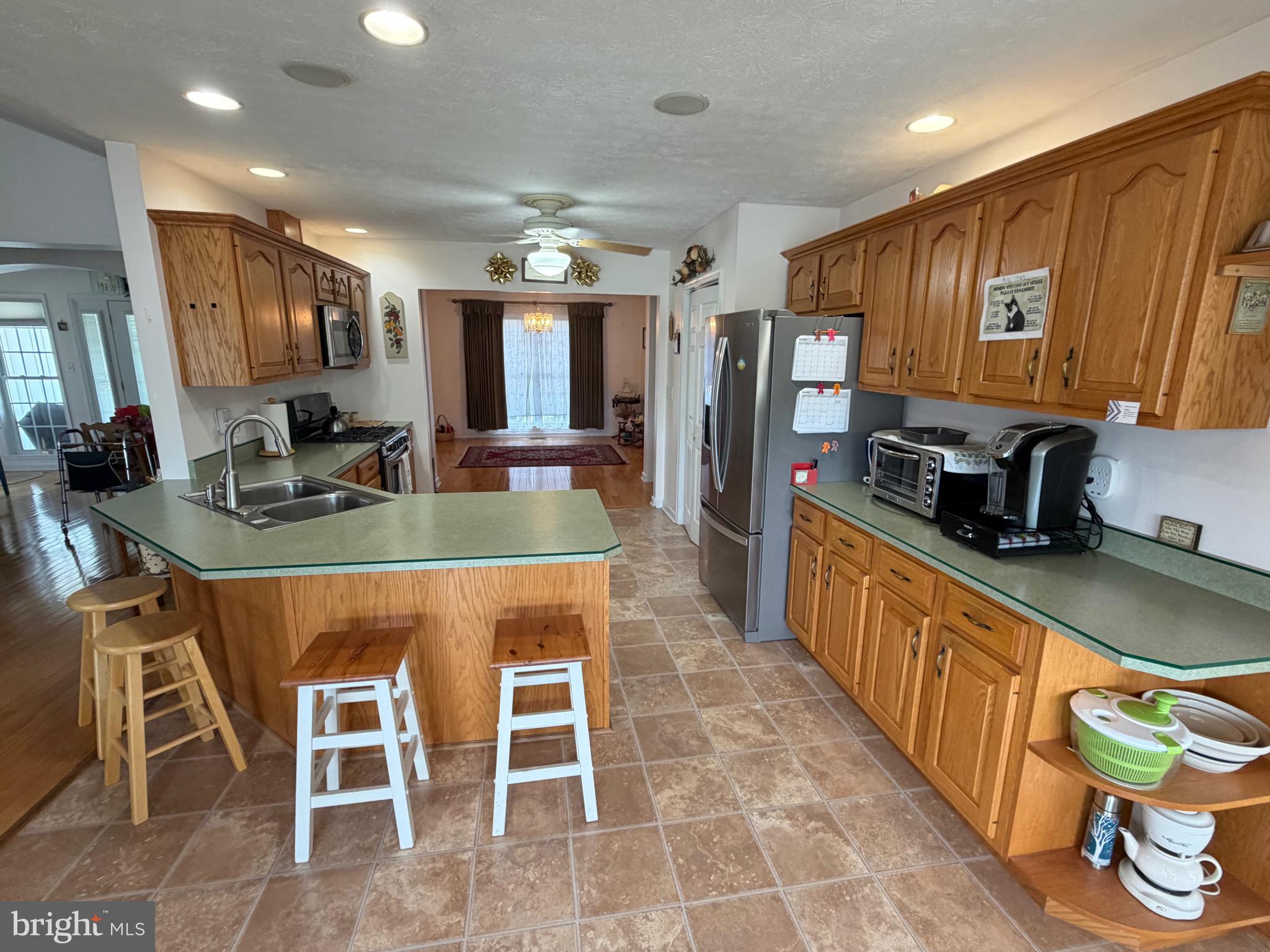 1565 Liberty Street Keyser, WV 26726 - Photo 7 of 95 a kitchen with stainless steel appliances granite countertop a stove top oven a sink a dining table and chairs with wooden floor