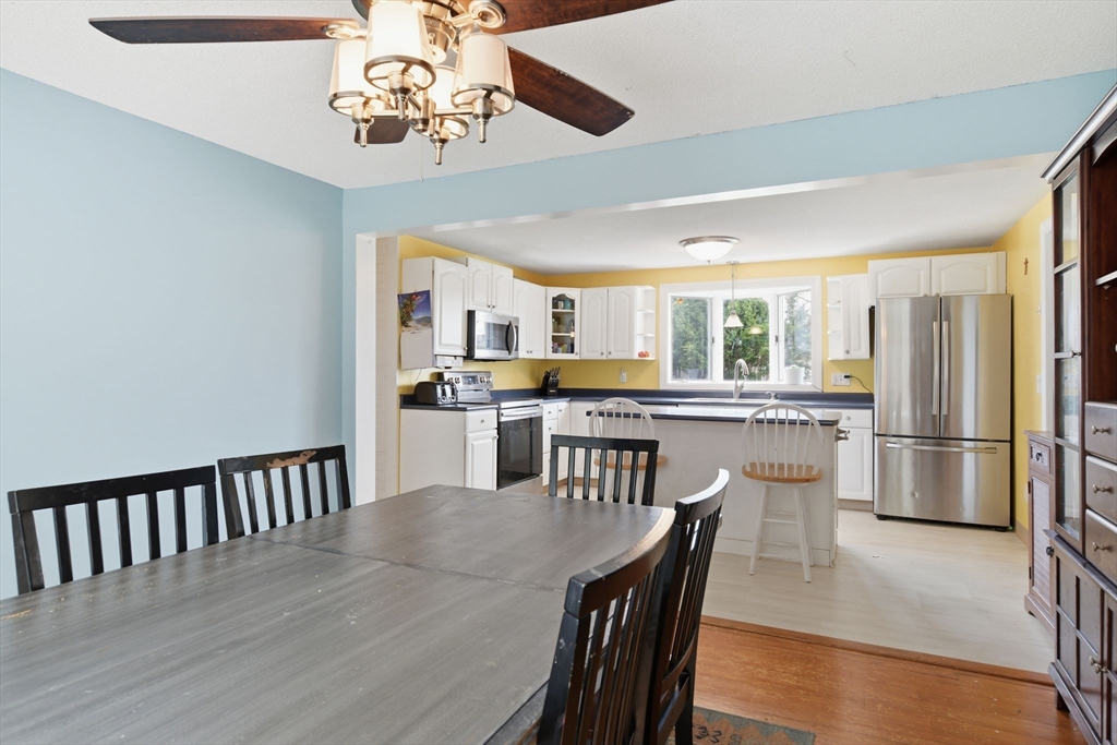 244 Lower Westfield Road Holyoke, MA 01040 - Photo 17 of 39 a dining room with stainless steel appliances kitchen island granite countertop a dining table chairs and a refrigerator