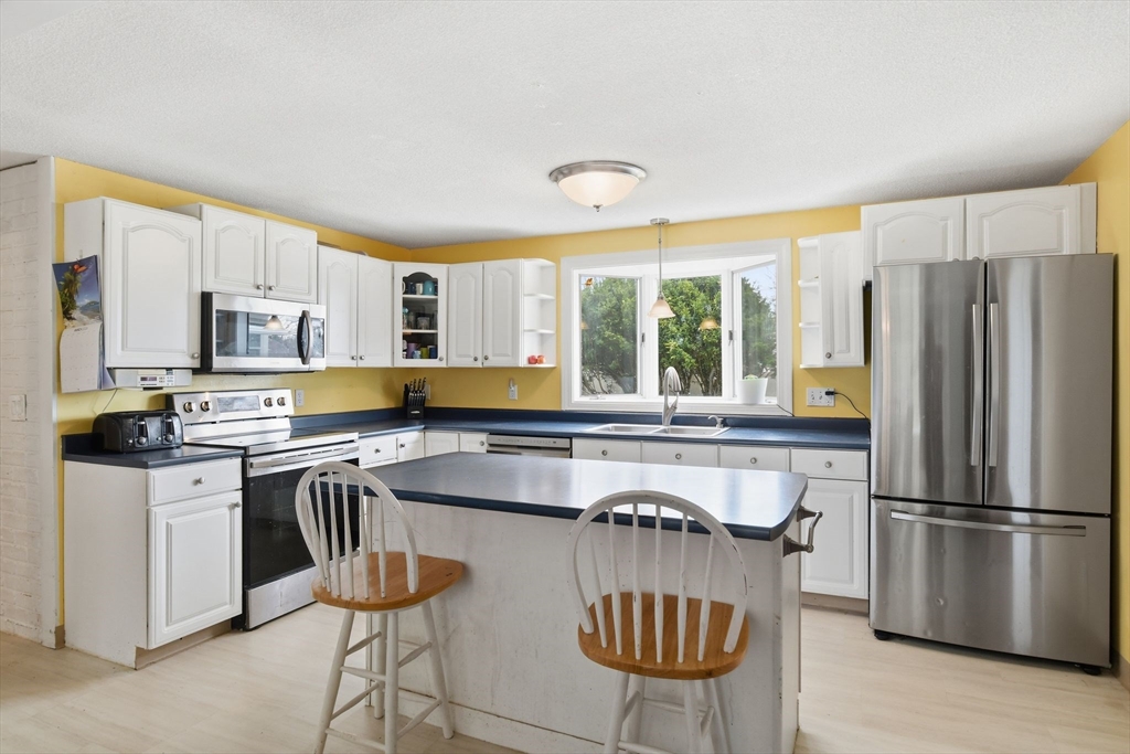244 Lower Westfield Road Holyoke, MA 01040 - Photo 18 of 39 a kitchen with stainless steel appliances granite countertop a stove a refrigerator a sink a stove and white cabinets