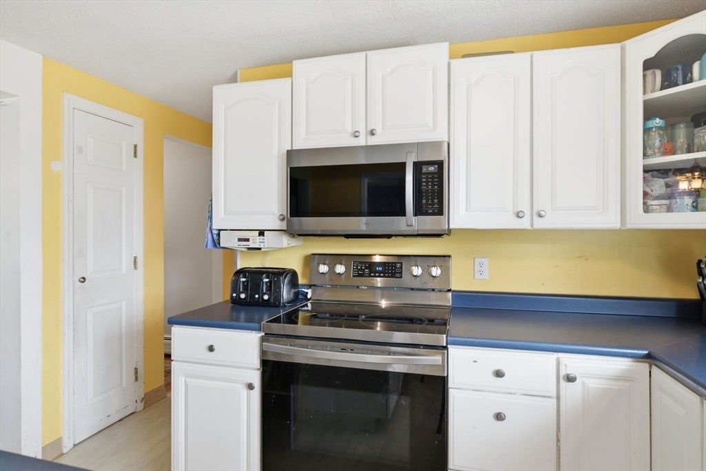 244 Lower Westfield Road Holyoke, MA 01040 - Photo 21 of 39 a kitchen with stainless steel appliances a stove a microwave and cabinets