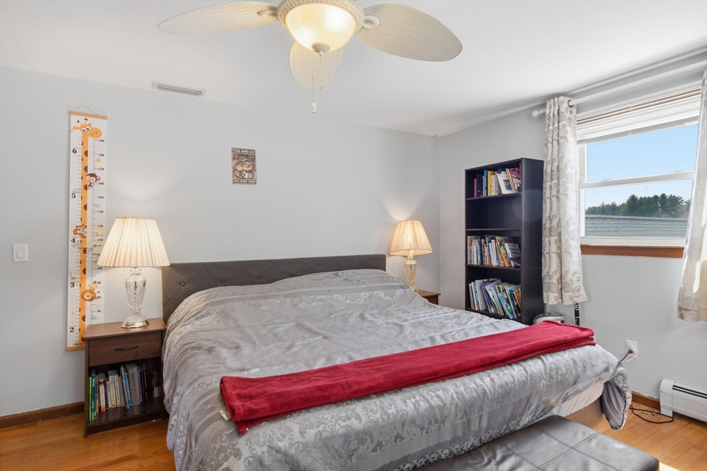 244 Lower Westfield Road Holyoke, MA 01040 - Photo 34 of 39 a bedroom with a large bed and a wooden floor