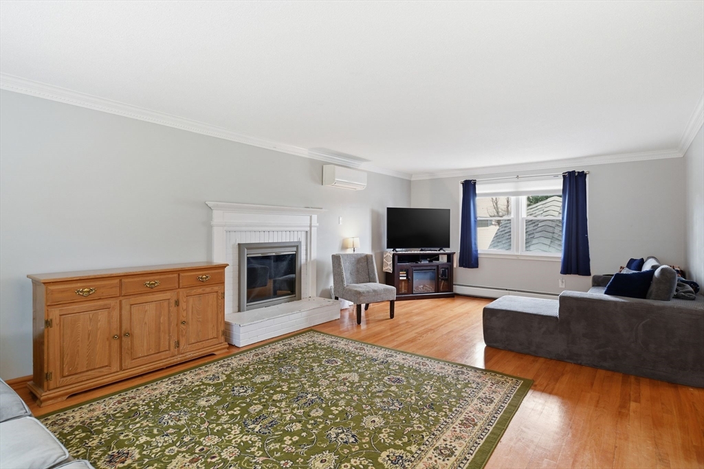 244 Lower Westfield Road Holyoke, MA 01040 - Photo 6 of 39 a living room with furniture a flat screen tv and a fireplace