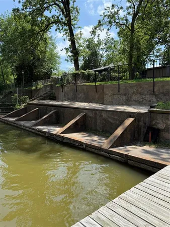 a view of a swimming pool with wooden floor and trees in the background