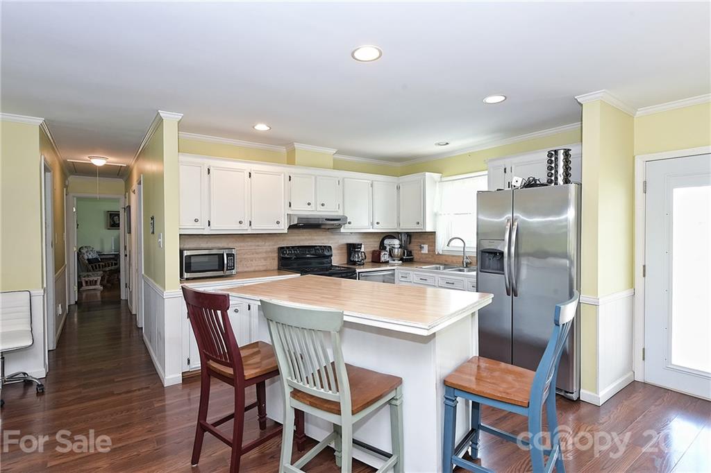 1721 Rock Rest Road Wingate, NC 28174 - Photo 20 of 47 a kitchen with stainless steel appliances granite countertop a refrigerator a stove a sink a dining table and chairs