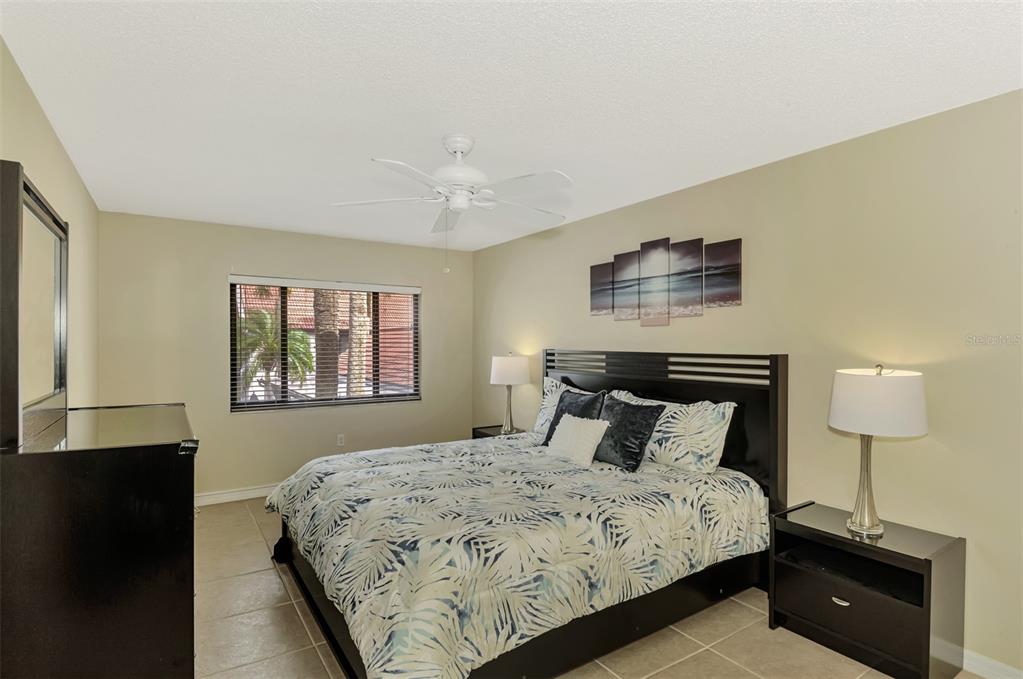 1618 Stickney Point Road, Unit 1618202 Sarasota, FL 34231 - Photo 28 of 58 a bedroom with a bed and a lamp on table