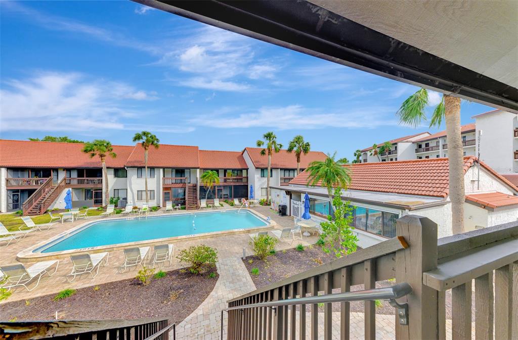 1618 Stickney Point Road, Unit 1618202 Sarasota, FL 34231 - Photo 40 of 58 a view of a patio with table and chairs under an umbrella
