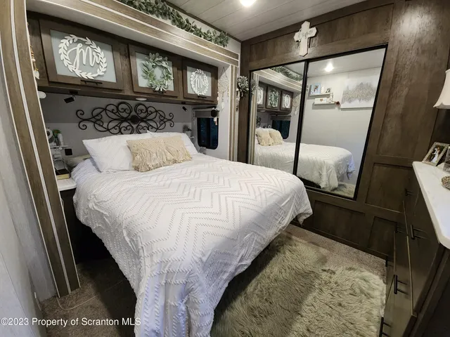 a bedroom with a bed and a flat tv screen on dresser
