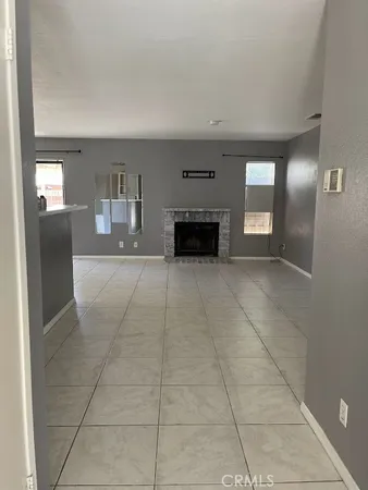 en empty room with a fireplace and windows