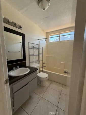 a bathroom with a granite countertop sink toilet a mirror and shower