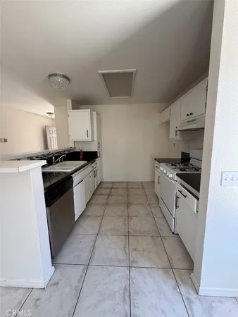 a kitchen with granite countertop a stove sink and cabinets