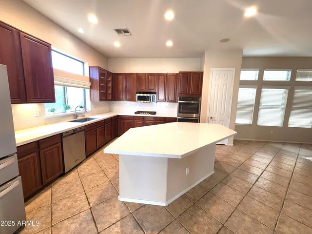 a large kitchen with kitchen island granite countertop a sink counter space and a large window