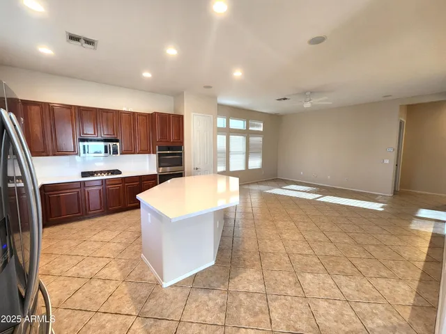 a kitchen with granite countertop a stove a sink and a microwave