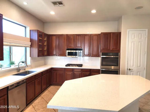 a kitchen with wooden cabinets and stainless steel appliances