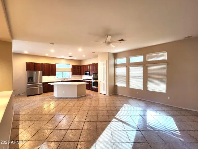 a large white kitchen with a large window and stainless steel appliances