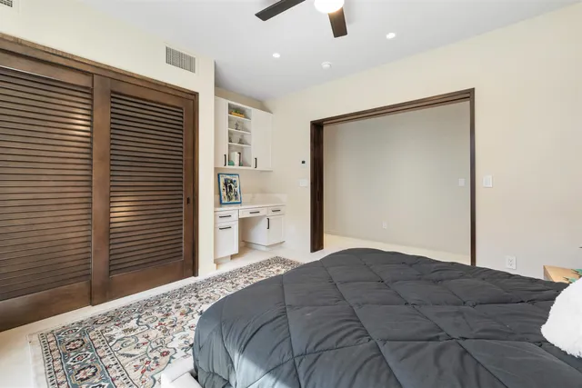 a bedroom with a bed and a lamp on dresser