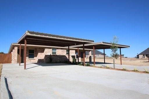 156 Crossbow Court Weatherford, TX 76088 - Photo 20 of 23 a view of patio with a table and chairs under an umbrella with a small yard