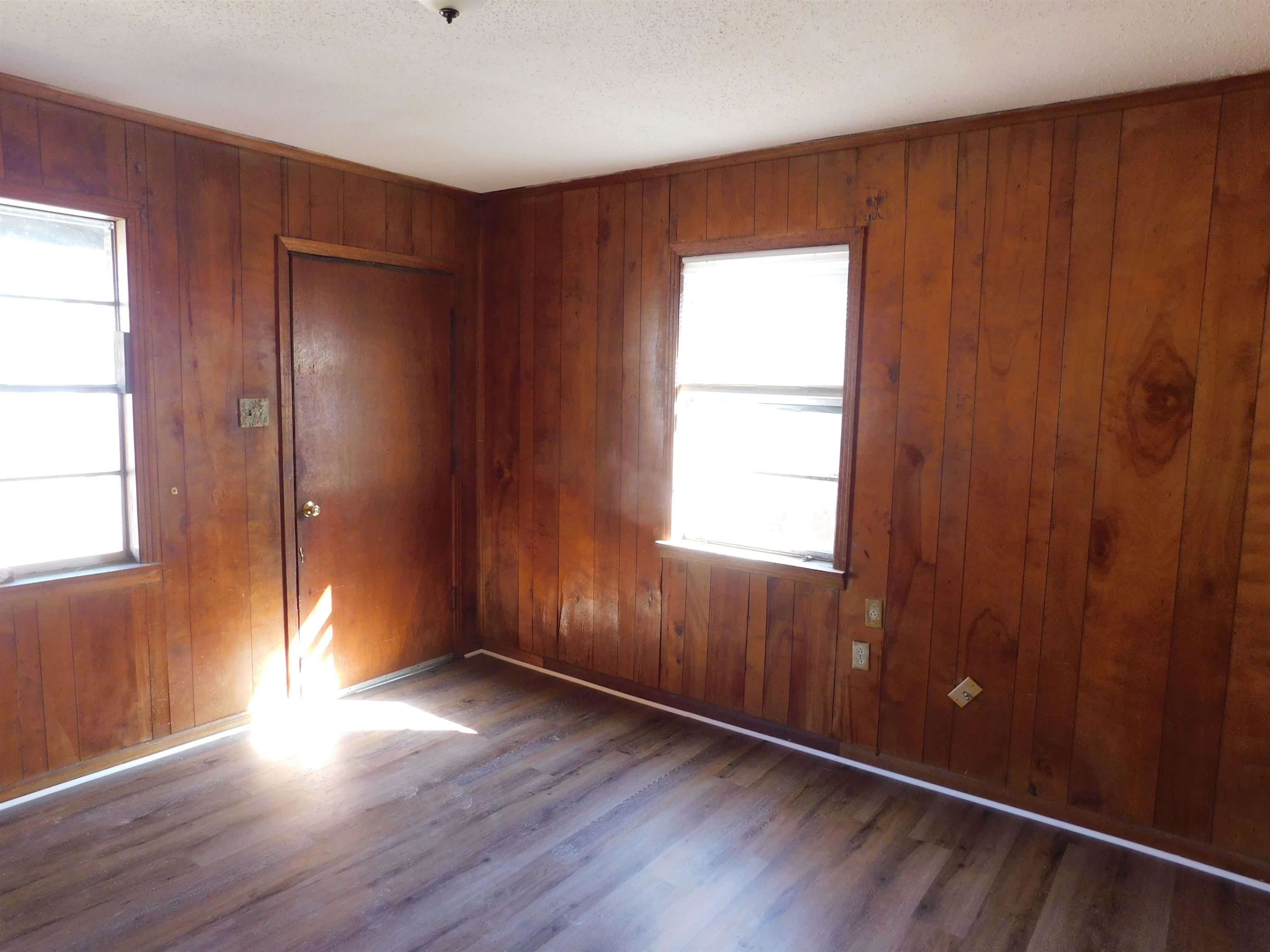 2367 Hubbard Avenue Memphis, TN 38108 - Photo 7 of 8 Spare room with dark wood-style flooring, wood walls, and a textured ceiling