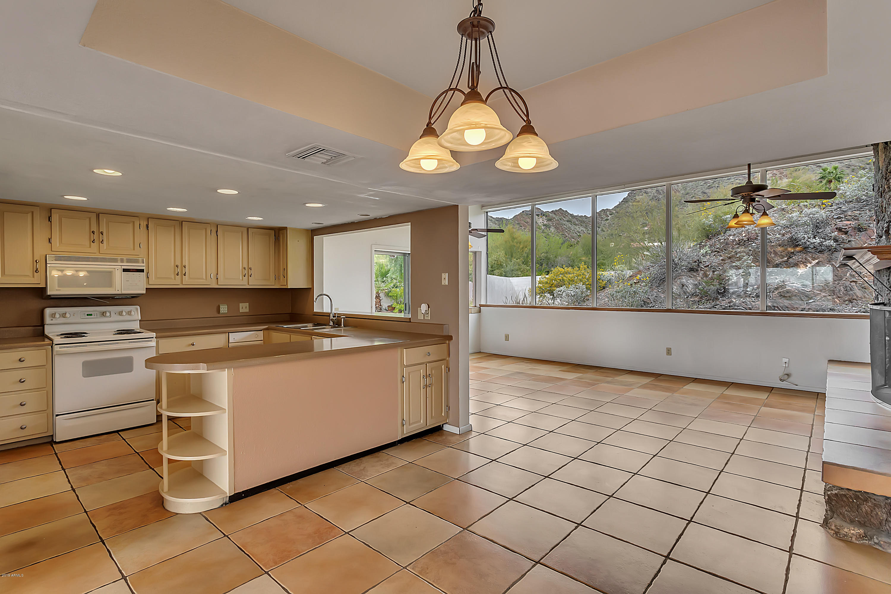 9601 North 17th Place Phoenix, AZ 85020 - Photo 5 of 16 a large white kitchen with a large window cabinets and stainless steel appliances