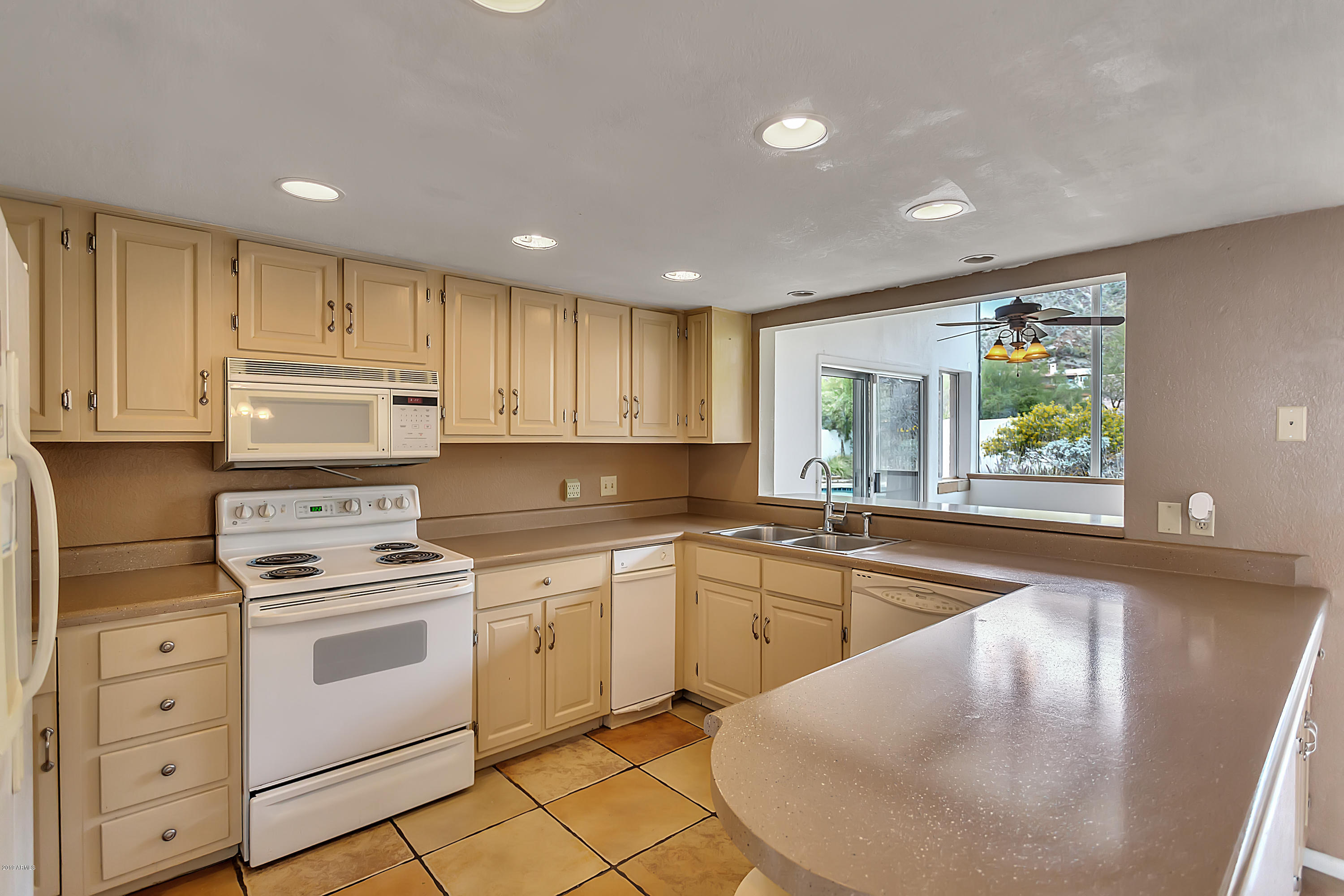 9601 North 17th Place Phoenix, AZ 85020 - Photo 6 of 16 a kitchen with granite countertop white cabinets and white appliances