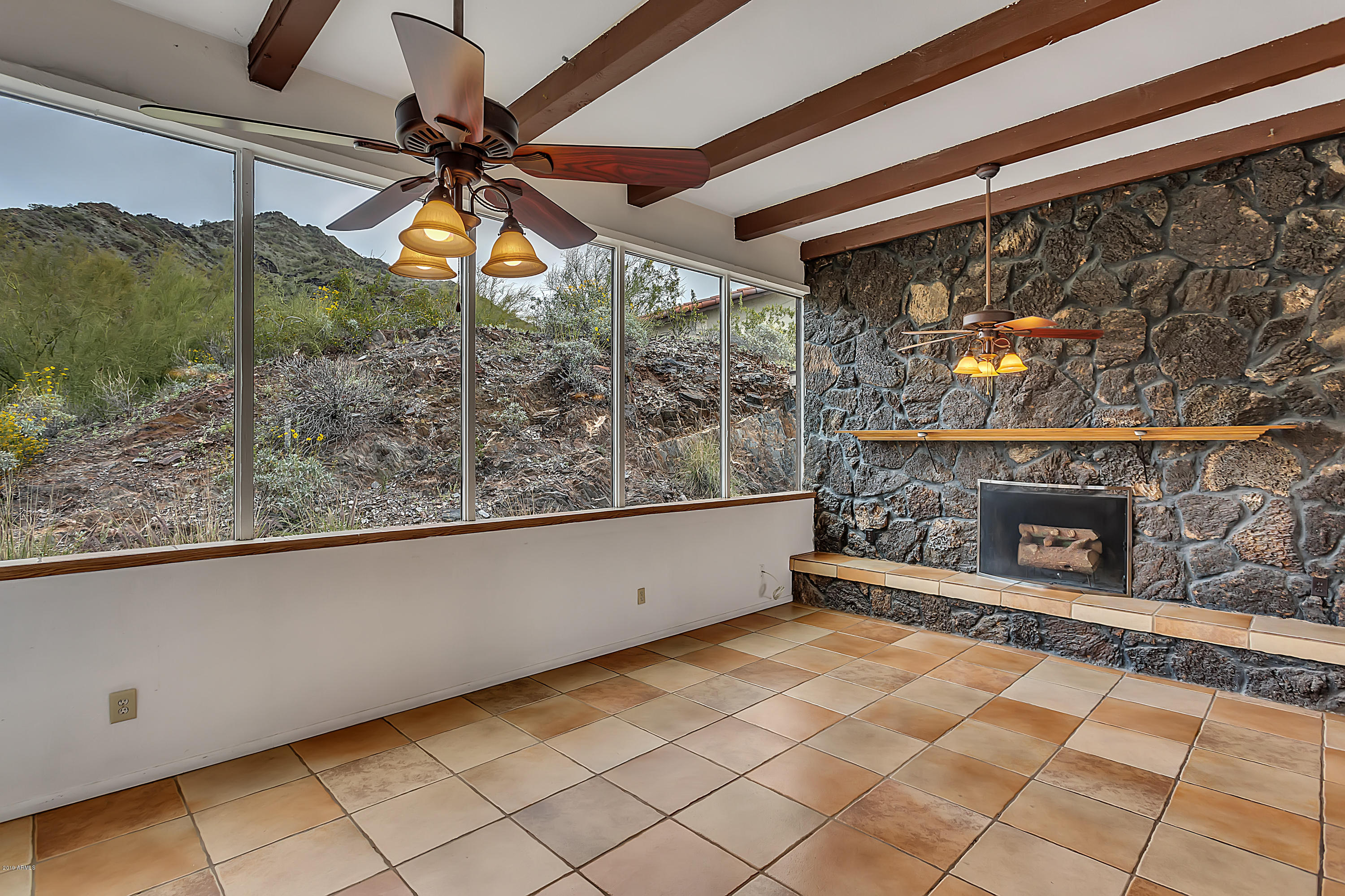 9601 North 17th Place Phoenix, AZ 85020 - Photo 8 of 16 a living room with a fireplace and a floor to ceiling window