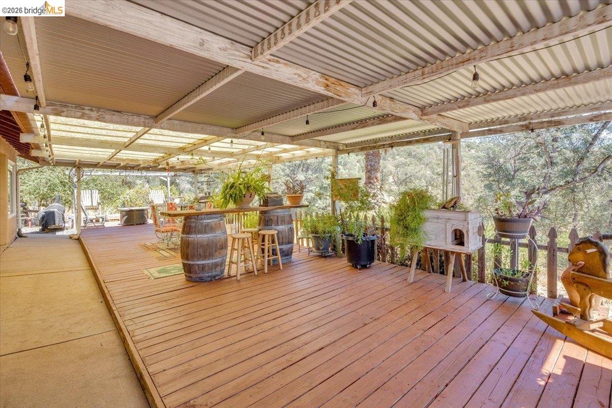 14450 Jacksonville Road Jamestown, CA 95327 - Photo 49 of 85 Expansive covered deck featuring wood-finish flooring, a corrugated metal roof, and exposed wood beams