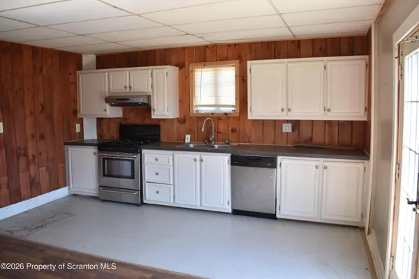 a kitchen with white cabinets and white appliances