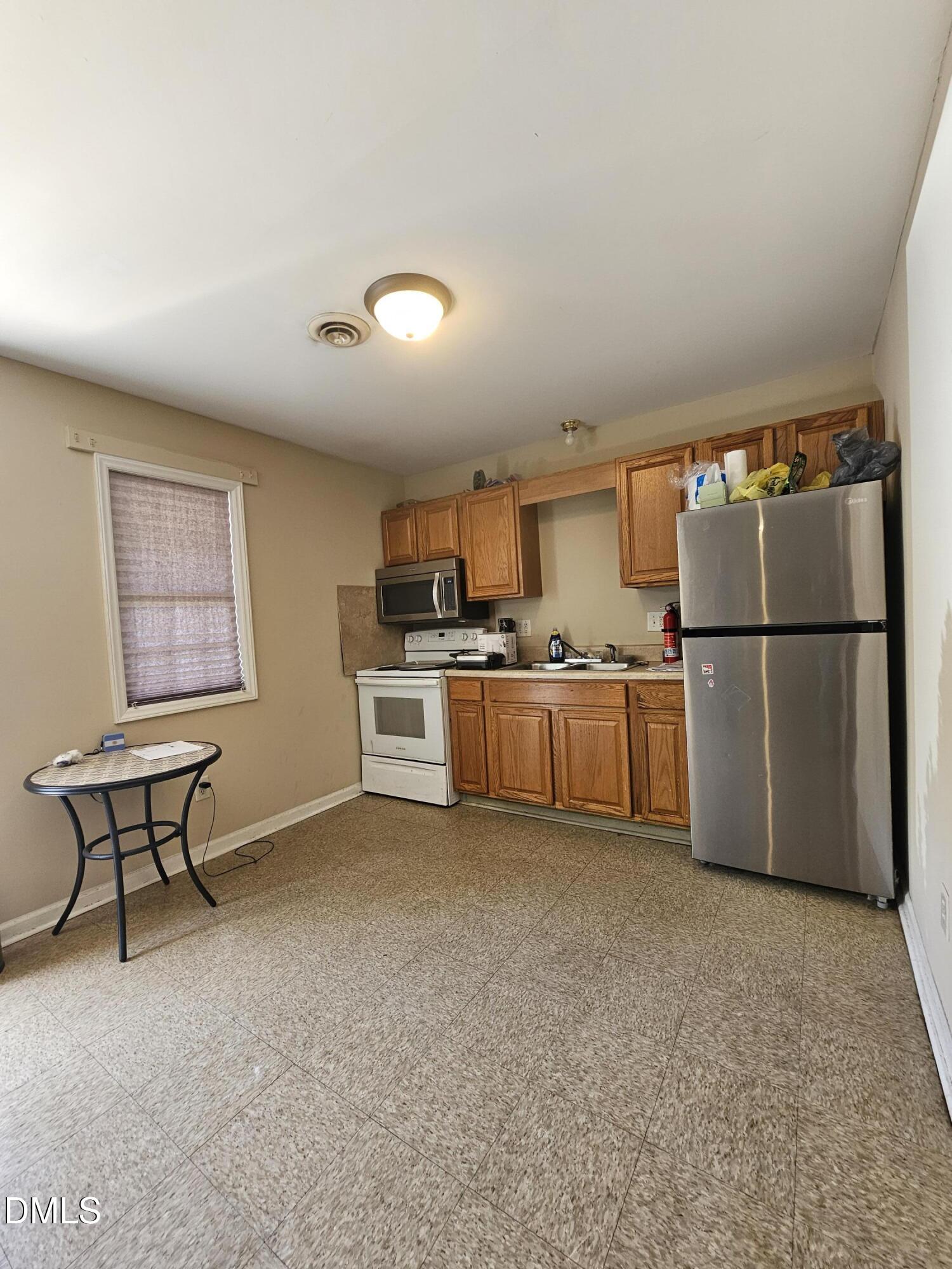 119 Lynn Drive Roxboro, NC 27573 - Photo 15 of 27 a kitchen with stainless steel appliances a refrigerator and a stove top oven