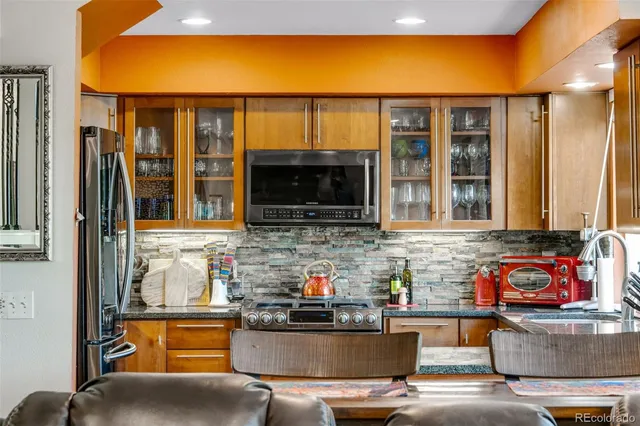 a living room with stainless steel appliances kitchen island granite countertop furniture and a flat screen tv