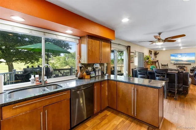 a view of a kitchen with kitchen island granite countertop a large window a sink and counter space