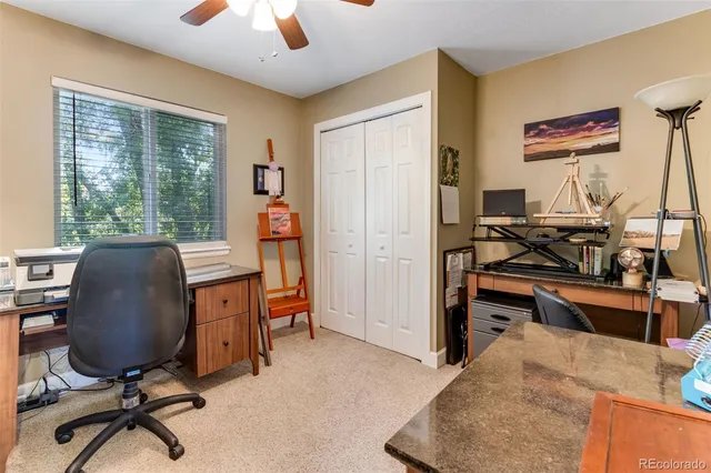 a view of a workspace with furniture and a window