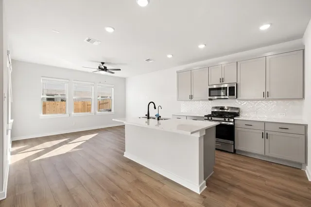 a kitchen with stainless steel appliances granite countertop a sink stove and refrigerator