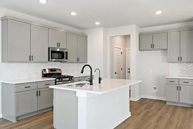 a kitchen with sink a microwave and cabinets