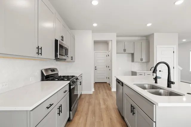 a kitchen with stainless steel appliances a sink stove top oven and cabinets