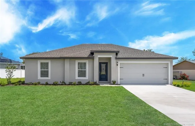 a front view of a house with a garden and yard