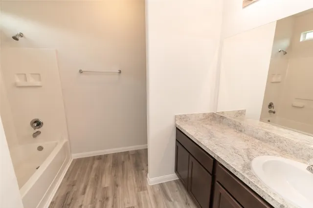 a bathroom with a granite countertop sink a toilet and shower