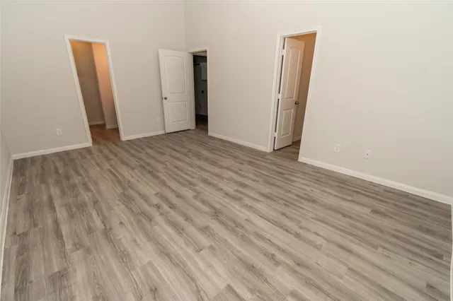 an empty room with wooden floor and closet