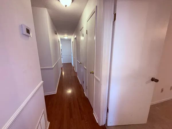 a view of a hallway with wooden floor and staircase